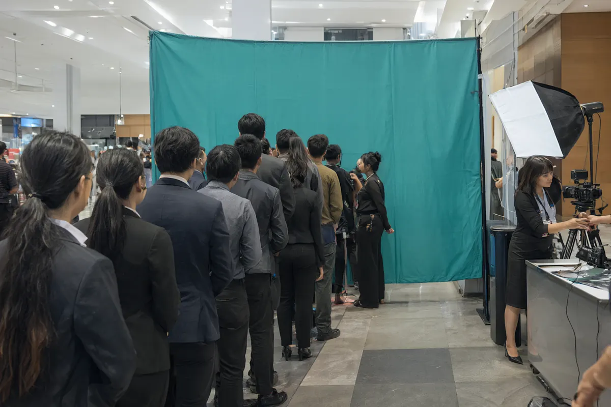 Antrean peserta seminar di photobooth dekat meja registrasi, dipandu staf