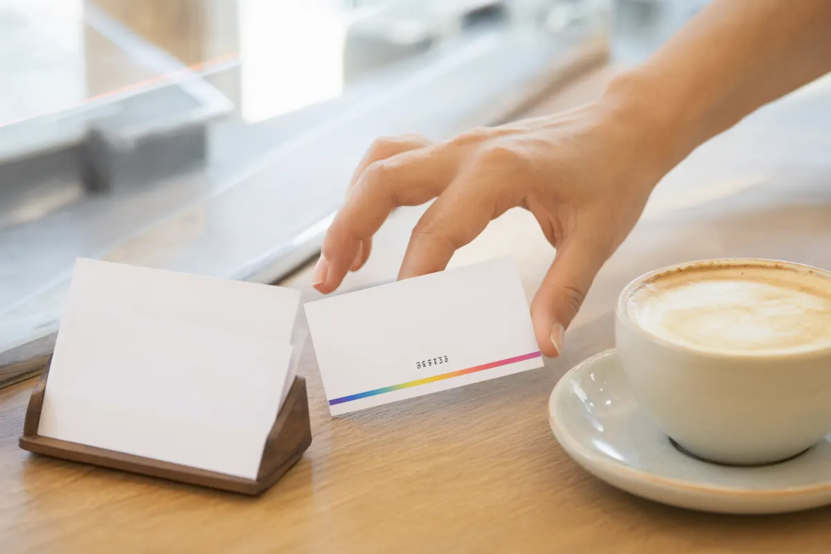 A voucher card handed over at a cafe counter next to a latte