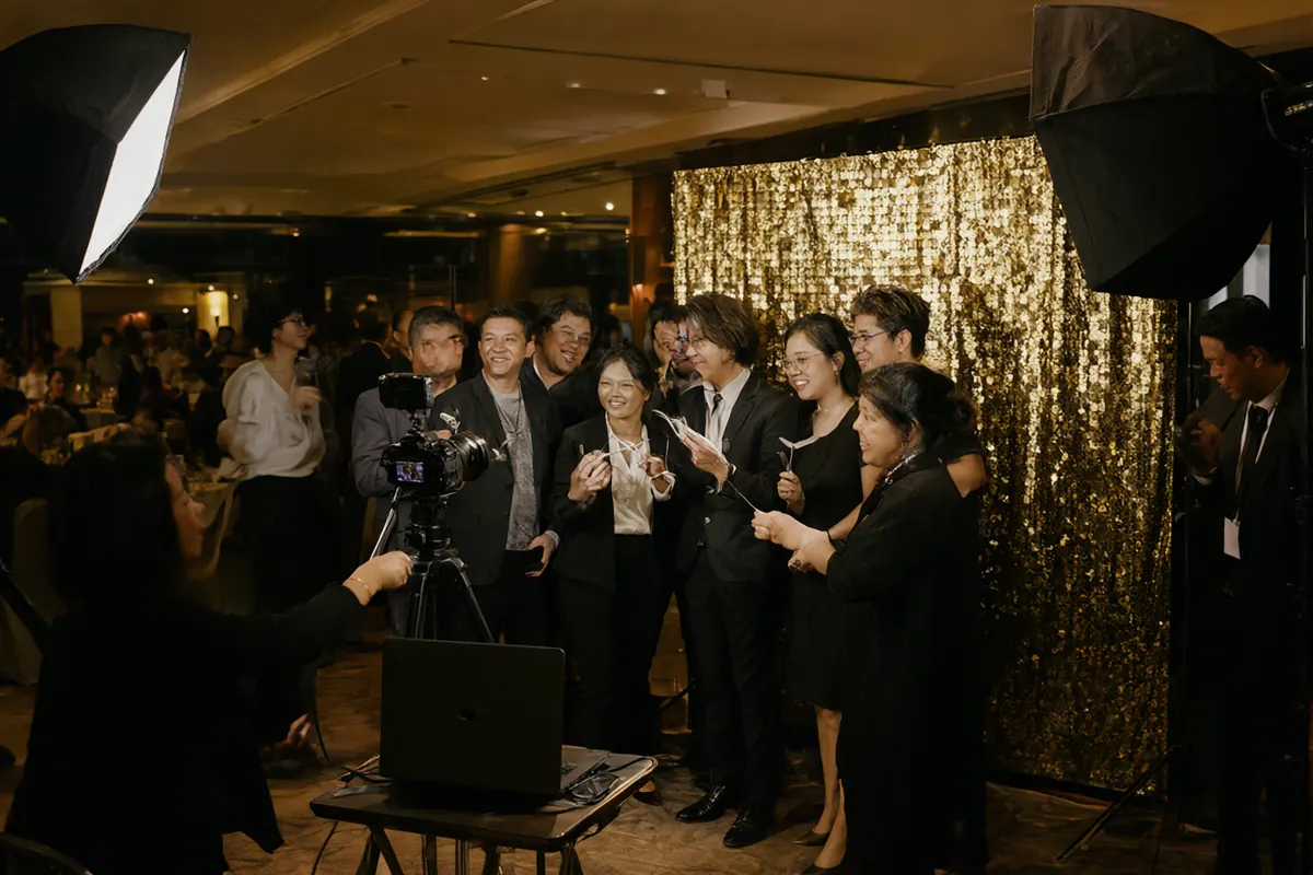 Photobooth event dengan backdrop sequin emas dan lampu softbox di gala dinner perusahaan