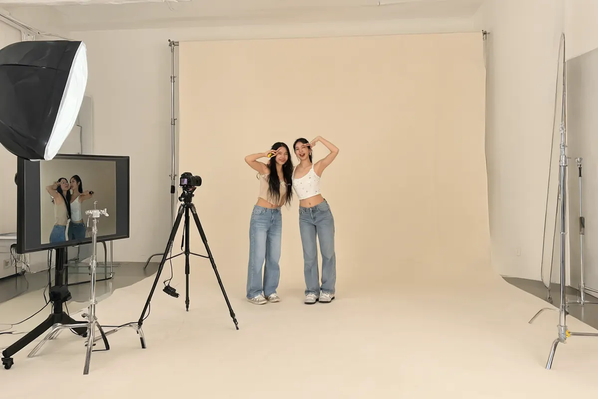 Dua sahabat berfoto sendiri di self-photo studio minimalis dengan remote dan monitor live view
